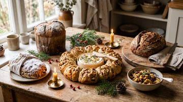 A festive table of Christmas sourdough bakes: panettone, stollen, a Camembert wreath, a cranberry loaf and stuffing