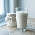 A tall glass of thick, creamy homemade milk kefir on a kitchen worktop
